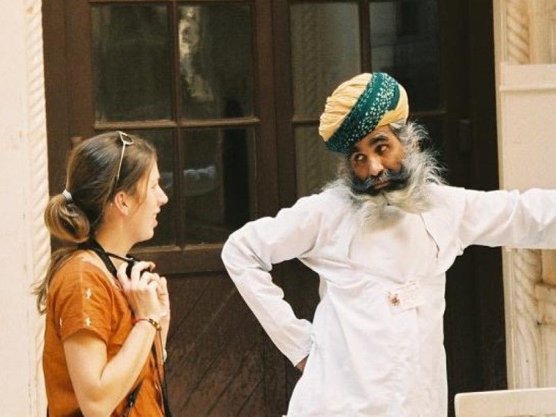 traditionell gekleideter Inder redet mit europäischer Frau